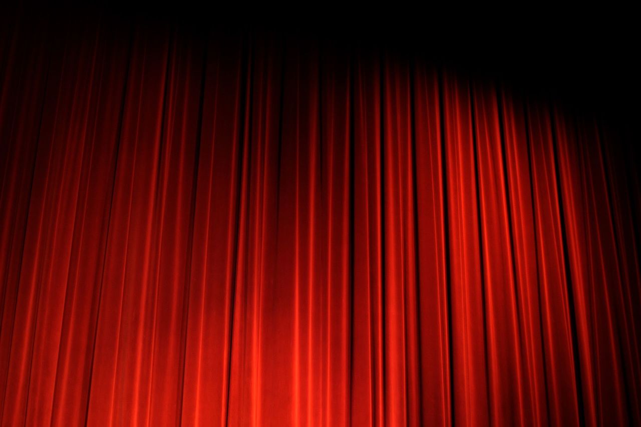 Sipario teatrale rosso illuminato dal basso